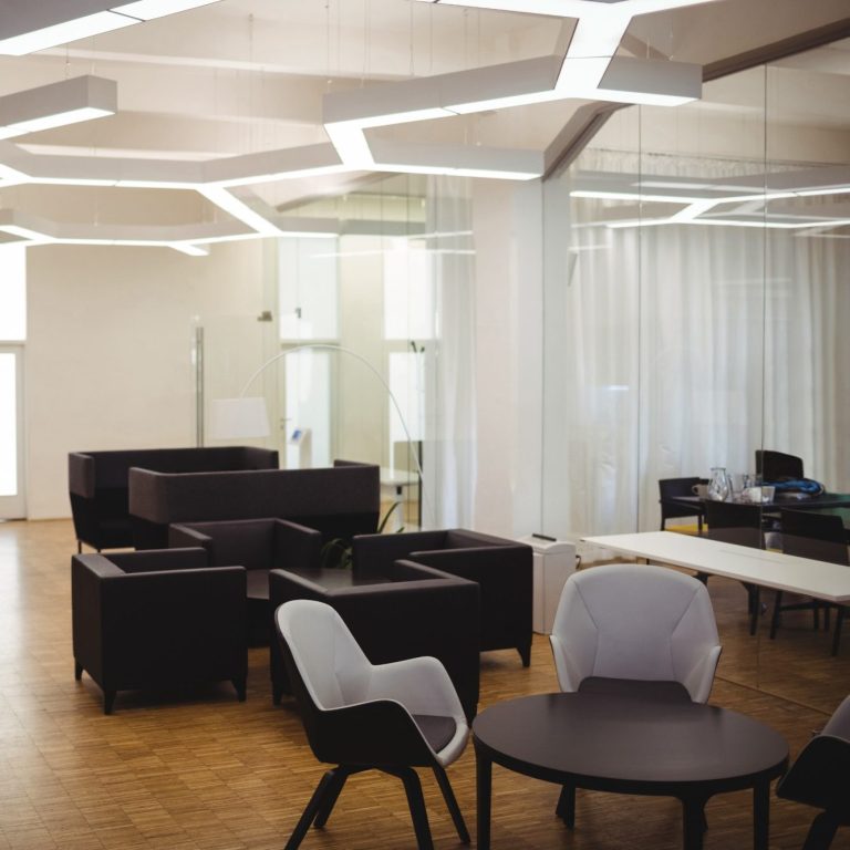 Oficina Espacio de oficina moderno con muebles oscurecidos y iluminación arquitectónica.